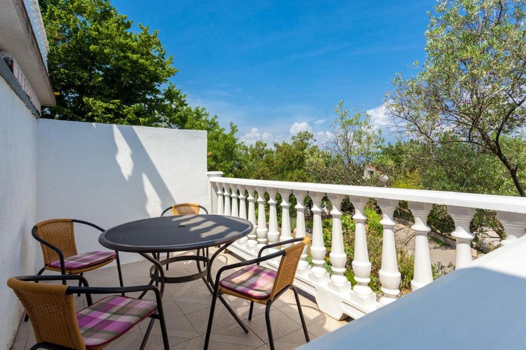 een patio met stoelen en een tafel op een balkon bij Apartments Magdalena in Malinska