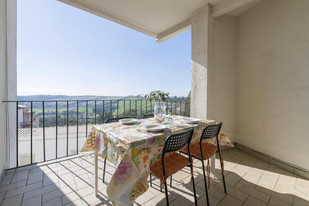 a table with chairs on a balcony with a view at Boliches in Arcos de la Frontera