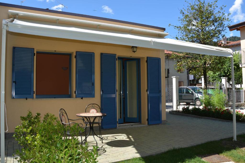 una casa con persianas azules y una mesa en el patio en Vacanze Casa di Trizzi, en Como