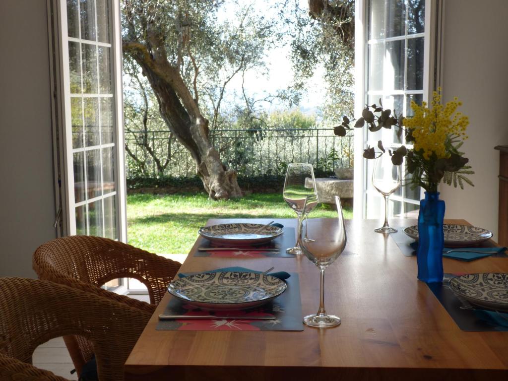 einen Tisch mit Tellern und Gläsern auf einem Tisch mit Fenster in der Unterkunft Apartment Cézanne mit geheiztem Pool und Privatgarten in Châteauneuf