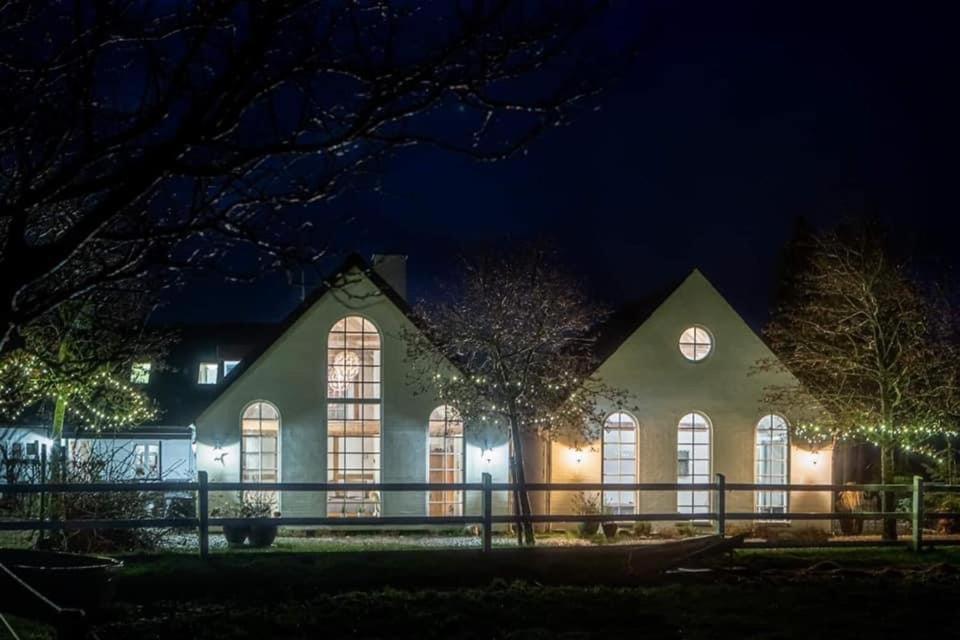 a large building with windows at night at Troldegaarden Guesthouse in Køge