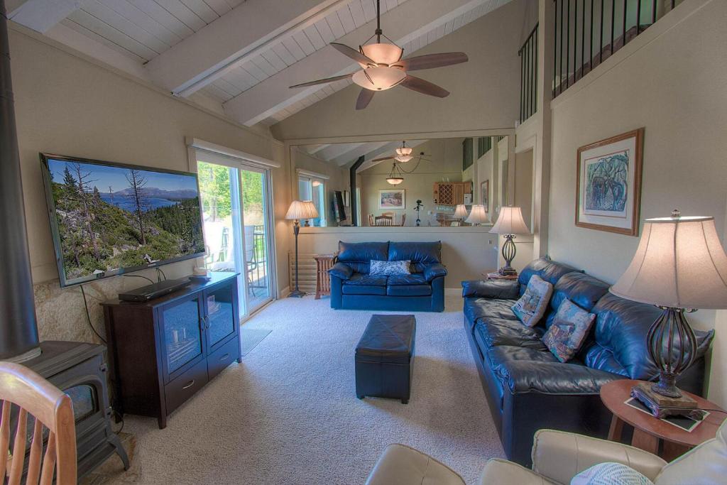 uma sala de estar com um sofá azul e uma ventoinha de tecto em Park View Paradise condo em Tahoe City