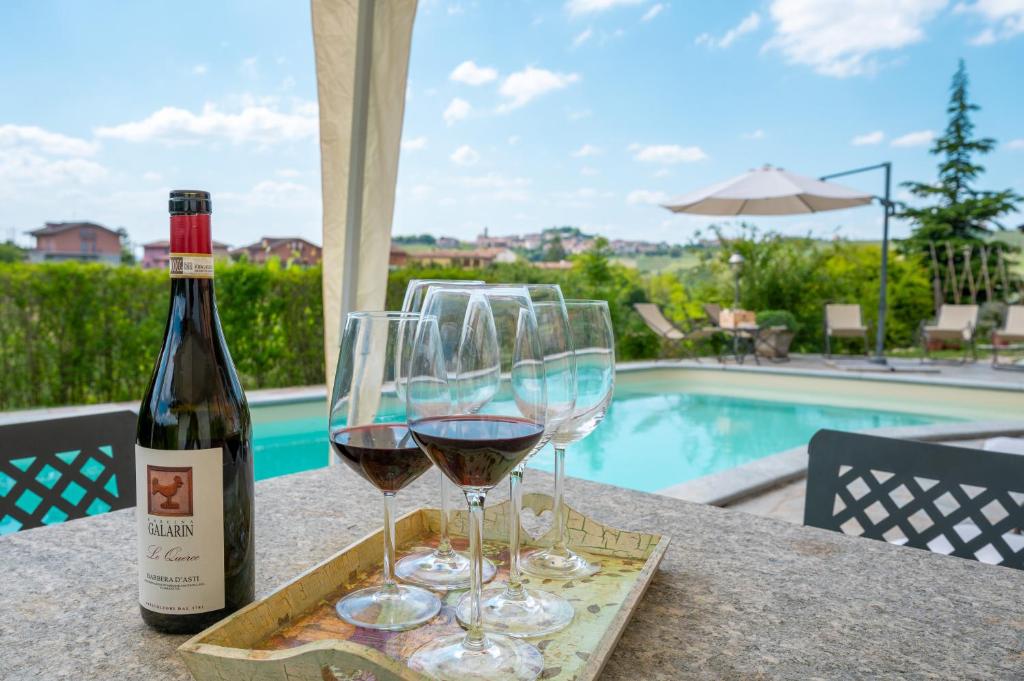 a bottle of wine and two glasses on a table at Cascina Galarin in Castagnole Lanze