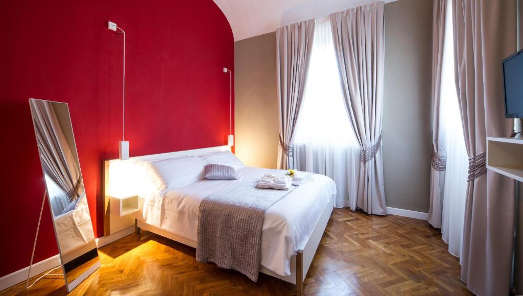 1 dormitorio con cama blanca y pared roja en Residenza d'Epoca Visacci, en Florencia