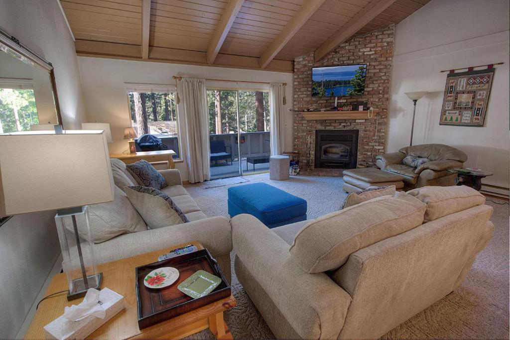 a living room with two couches and a fireplace at Whispering Wood home in Incline Village