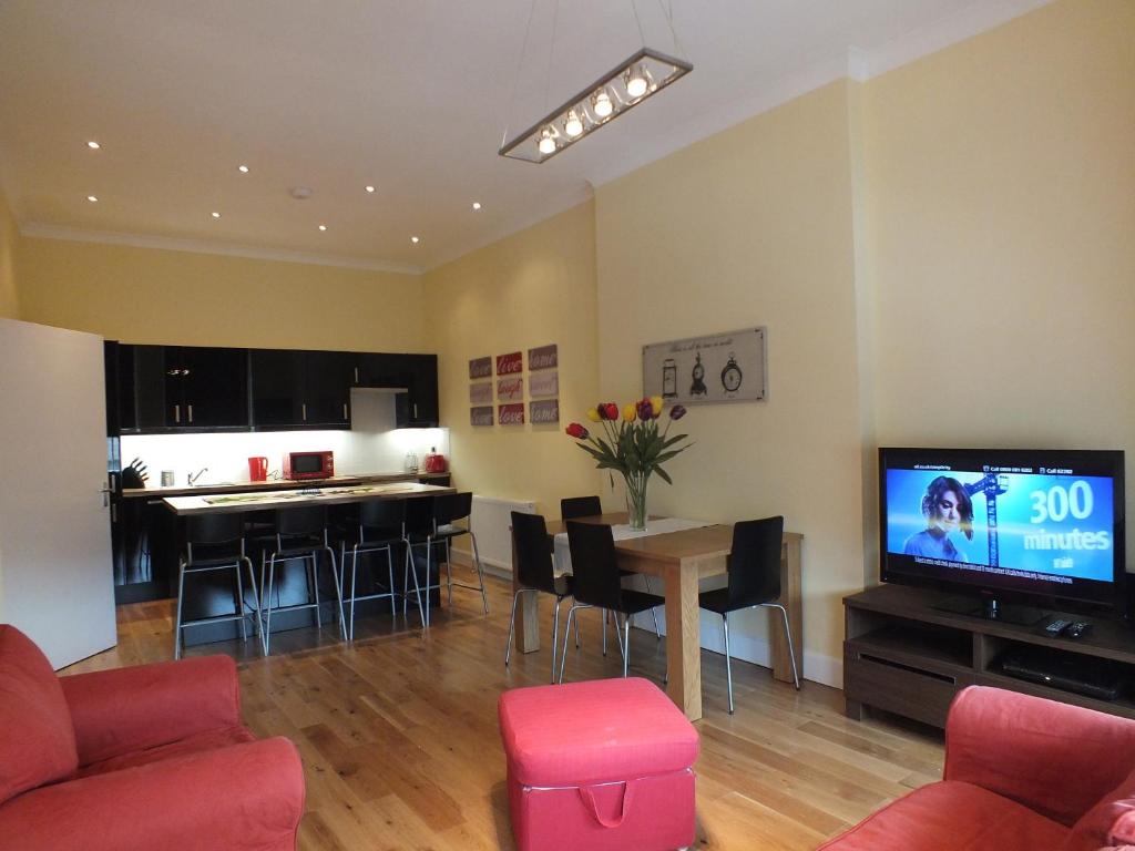 a living room with a couch and a table with a tv at Picardy Place Apartment in Edinburgh