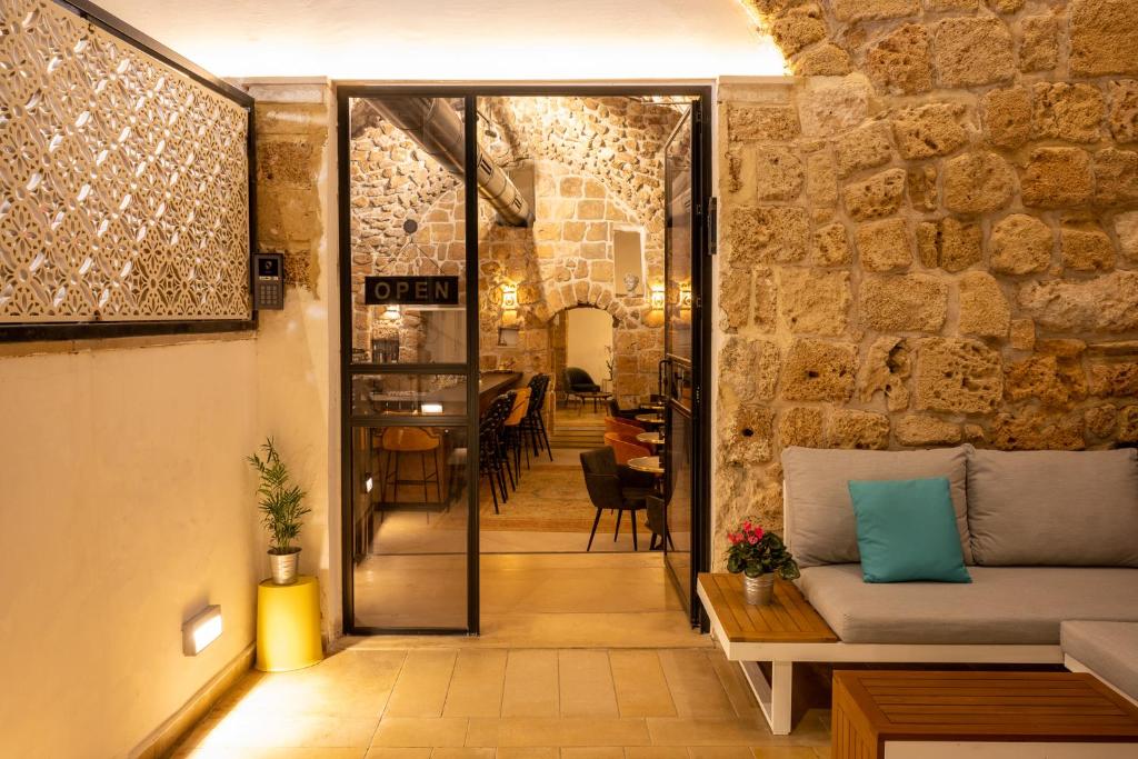 a room with a stone wall and a couch at Akotika boutique in Acre