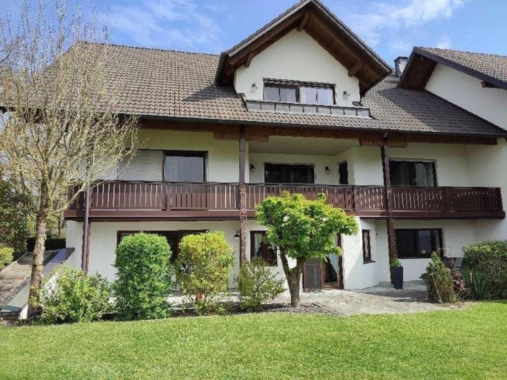 a large house with a deck on the front of it at Gästewohnung Mühlstein in Hohenthann