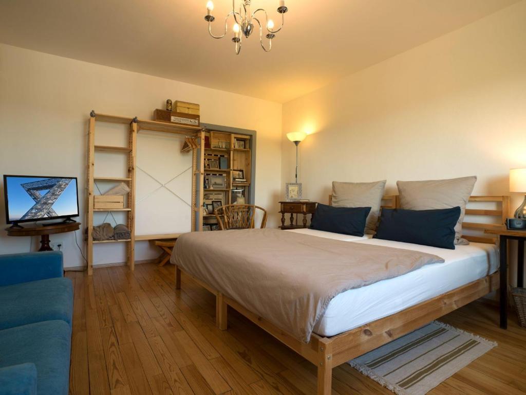 um quarto com uma cama grande e um sofá azul em Müllers WohnRäume em Saarlouis