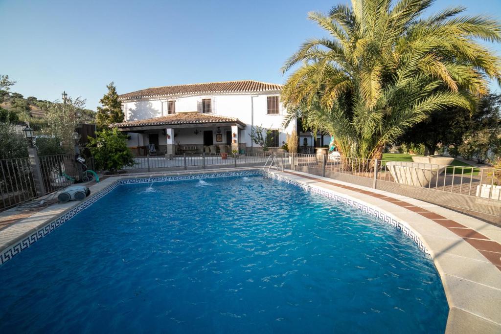 a swimming pool in front of a house at Cortijo El Segador y El Capricho in Almedinilla