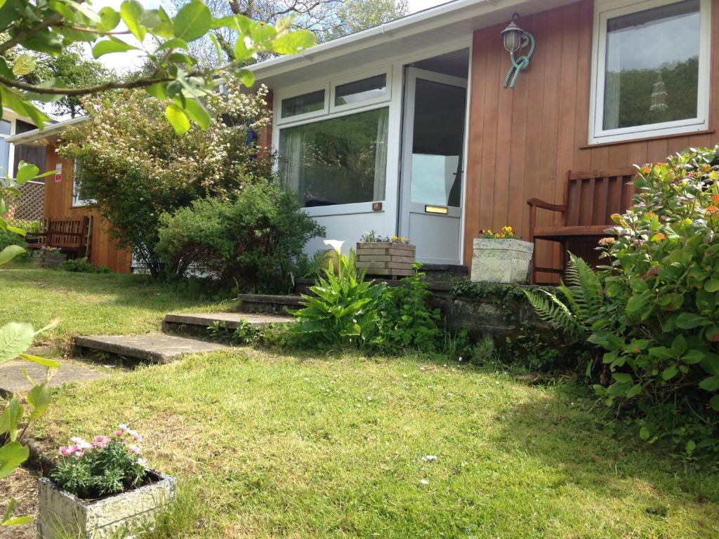 uma casa com uma porta branca e um quintal em Whiteshell Chalets em The Mumbles