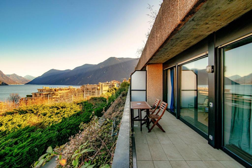 un balcone di una casa con tavolo e sedie di Paradise by Quokka 360 - with a 180 view of the Gulf of Lugano a Paradiso