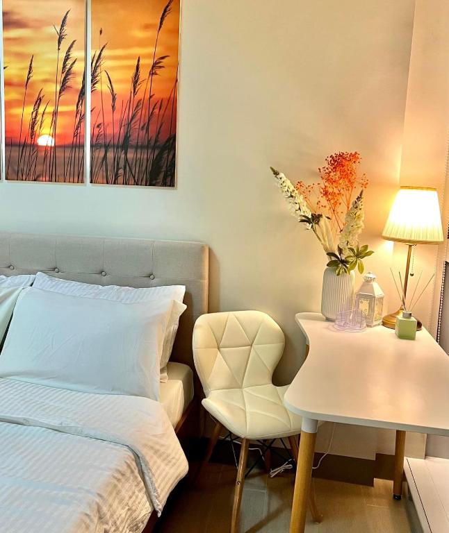 - une chambre avec un lit et une table avec une chaise dans l'établissement LOVELY AND COZY -Executive 1BR in Uptown Parksuites Tower 1-BGC, à Manille