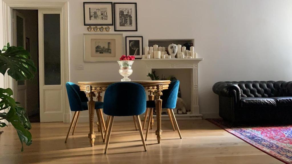 a dining room with a table and blue chairs at Bohemian House in Milan