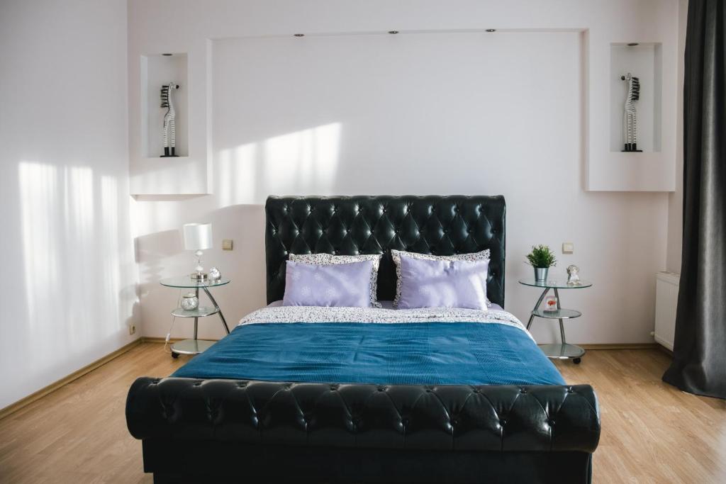 尤爾馬拉的住宿－Māja Rubeņi，一张黑色皮革床,配有蓝色床单和枕头