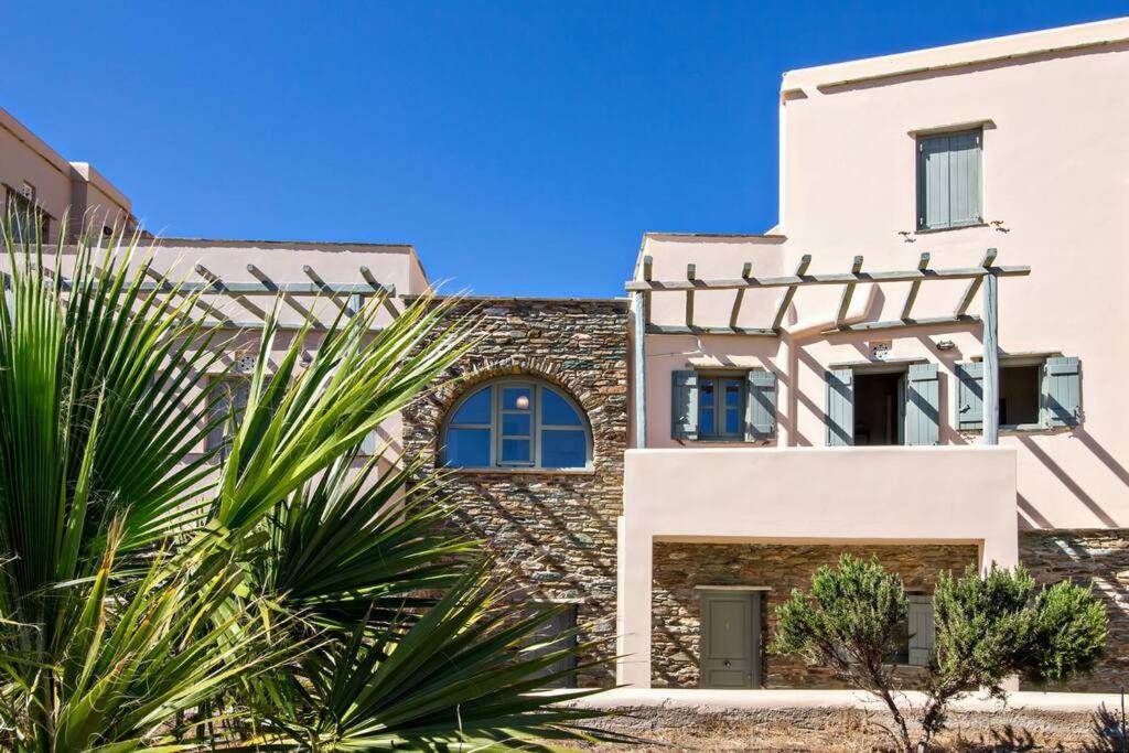 a house with a stone facade and palm trees at m.houses1 in Agios Romanos