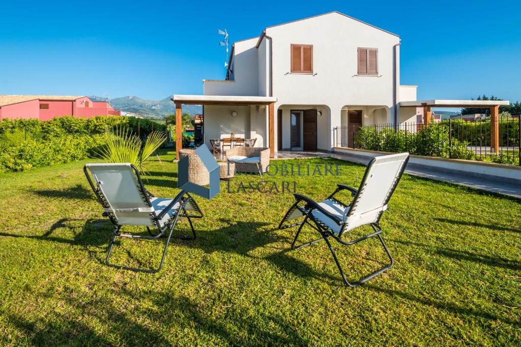 due sedie sedute sull'erba di fronte a una casa di Villa Laura a Lascari