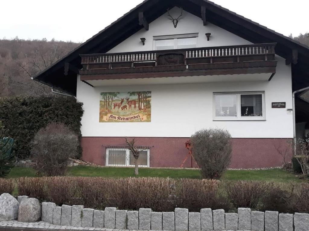 uma casa com um sinal ao lado dela em Ferienwohnung Am Rehwinkel em Fuldatal