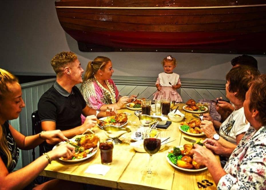 um grupo de pessoas sentadas à volta de uma mesa a comer em Lakeside Holiday Park em Burnham on Sea