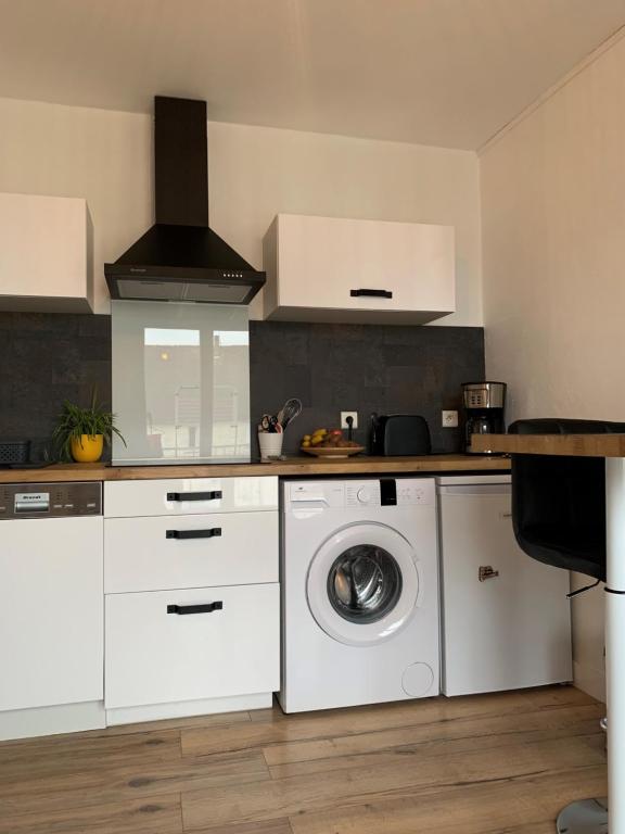 een witte keuken met een wasmachine bij Beau studio à 150 m de la plage in Ploemeur