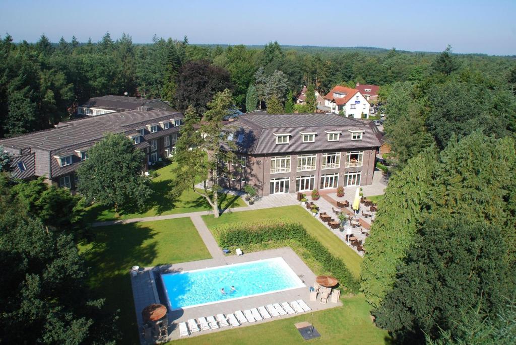 een luchtzicht op een herenhuis met een zwembad bij Hotel De Werelt Garderen in Garderen