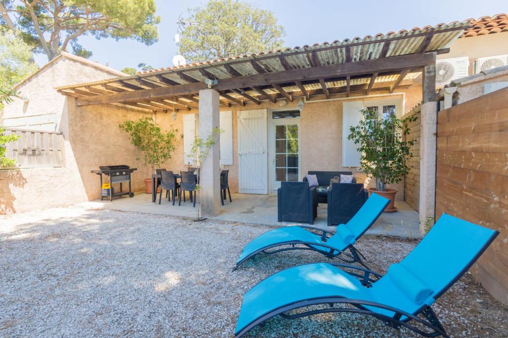 a patio with blue chairs and a pergola at Le Mas, maison au charme provençale idéalement située entre mer et vignes in Hyères