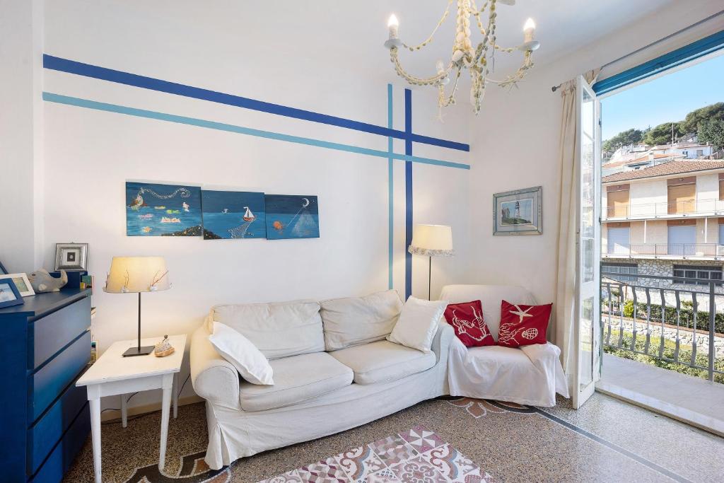 ein Wohnzimmer mit einem weißen Sofa und einem Fenster in der Unterkunft Casa Cecilia in Marina dʼAndora