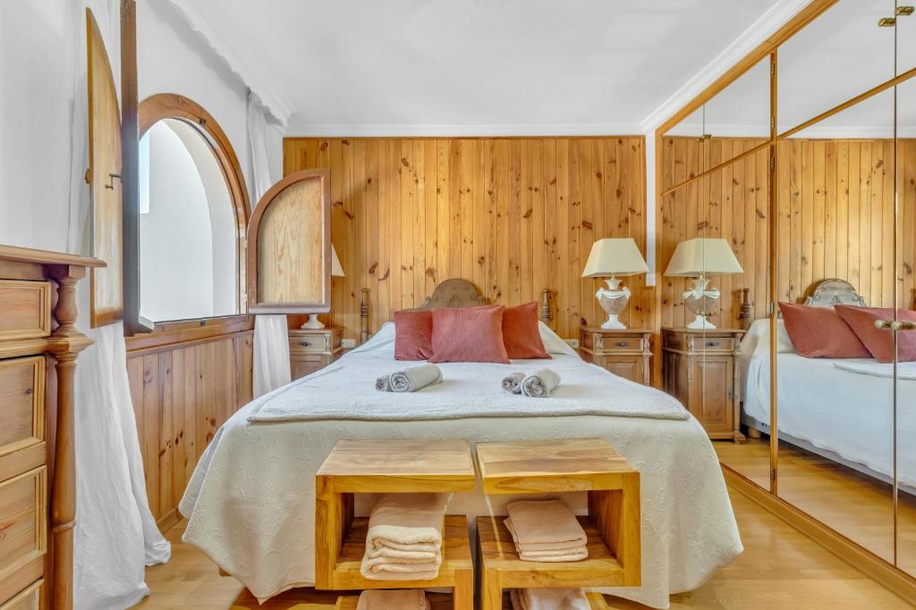 sypialnia z dużym łóżkiem i drewnianymi ścianami w obiekcie Casa temática Andaluza con vistas al valle - El Mirador de Benahavis w mieście Benahavís