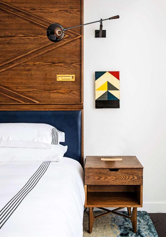 a bedroom with a bed and a wooden headboard at Thompson Nashville, by Hyatt in Nashville