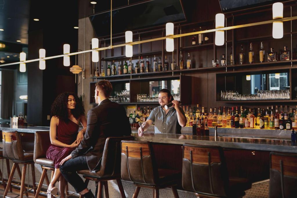 a group of people sitting at a bar at Thompson Nashville, by Hyatt in Nashville