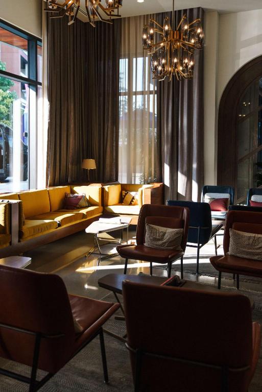a living room with couches and chairs and a chandelier at Thompson Nashville, by Hyatt in Nashville