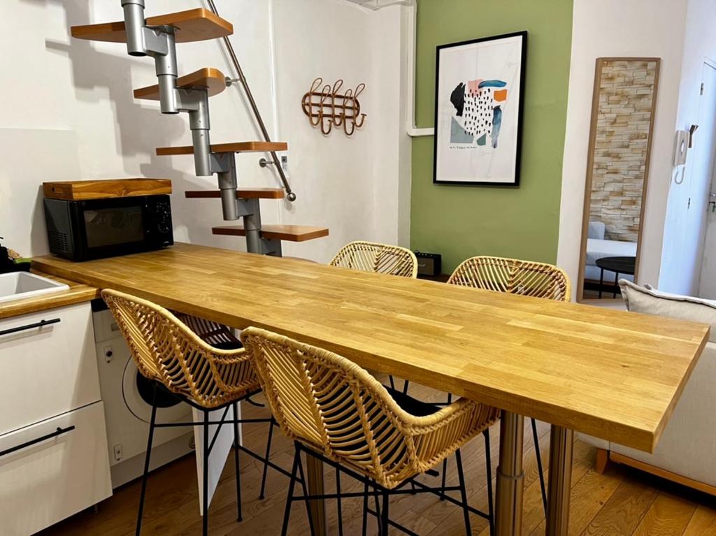 een keuken met een houten tafel en stoelen bij Chez Lise in Montpellier