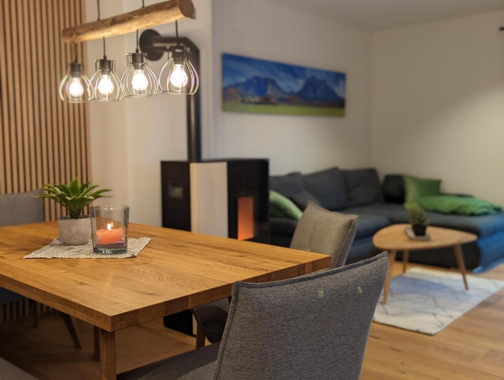 uma sala de estar com uma mesa de madeira com uma vela em ApartSchön em Schwangau