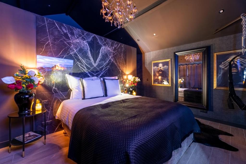 - une chambre dotée d'un lit avec un mur violet dans l'établissement Balnéo, sauna, free champagne et de nombreuses surprises, à Rouen