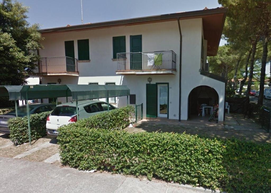 a white car parked in front of a building at Beautiful Two-Bedroom Villa in Bibione - Beahost in Bibione