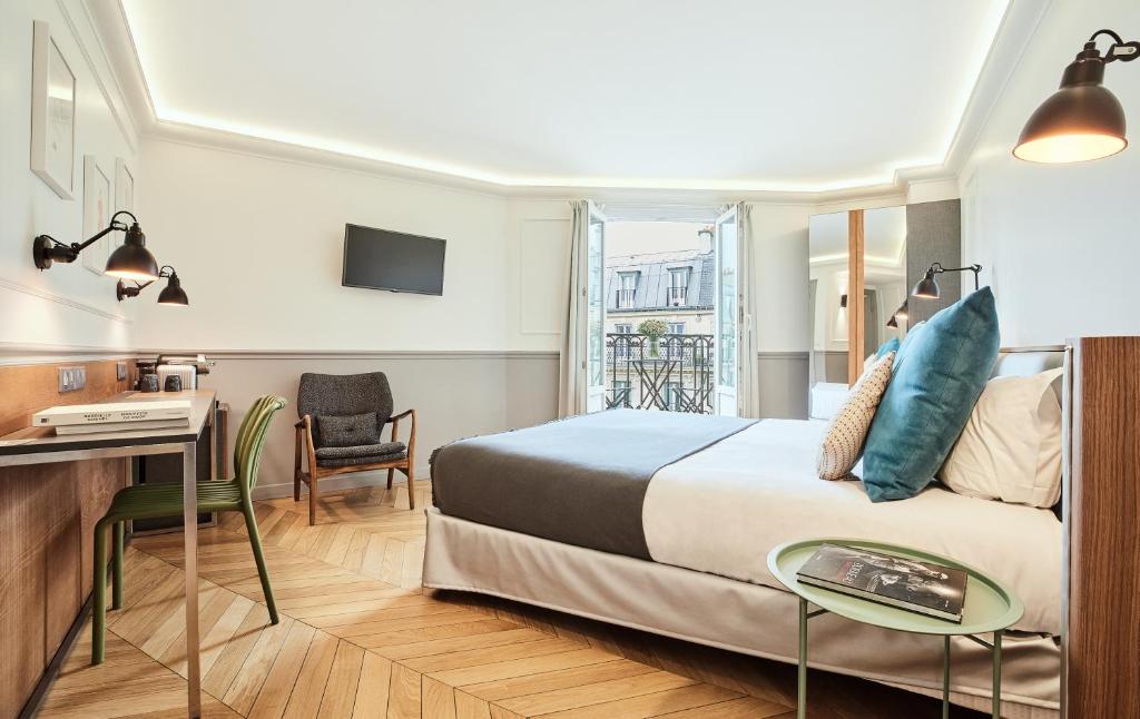 Cette chambre comprend un lit et un bureau. dans l'établissement Hotel Petit Lafayette, à Paris