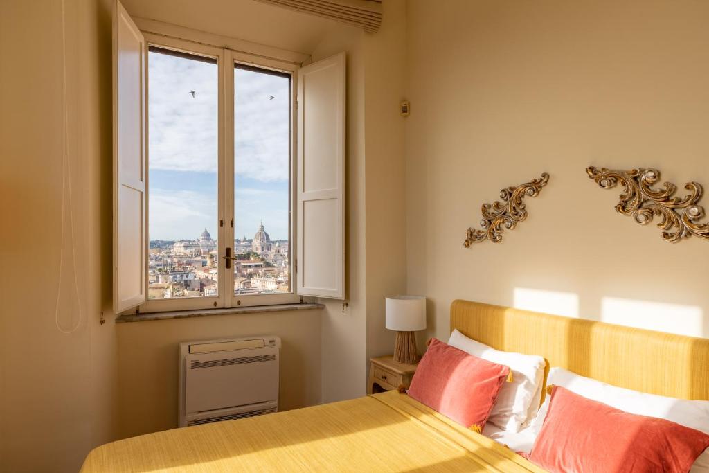 a bedroom with a bed and a window with a view at iFlat Spanish Steps at your Feet in Rome