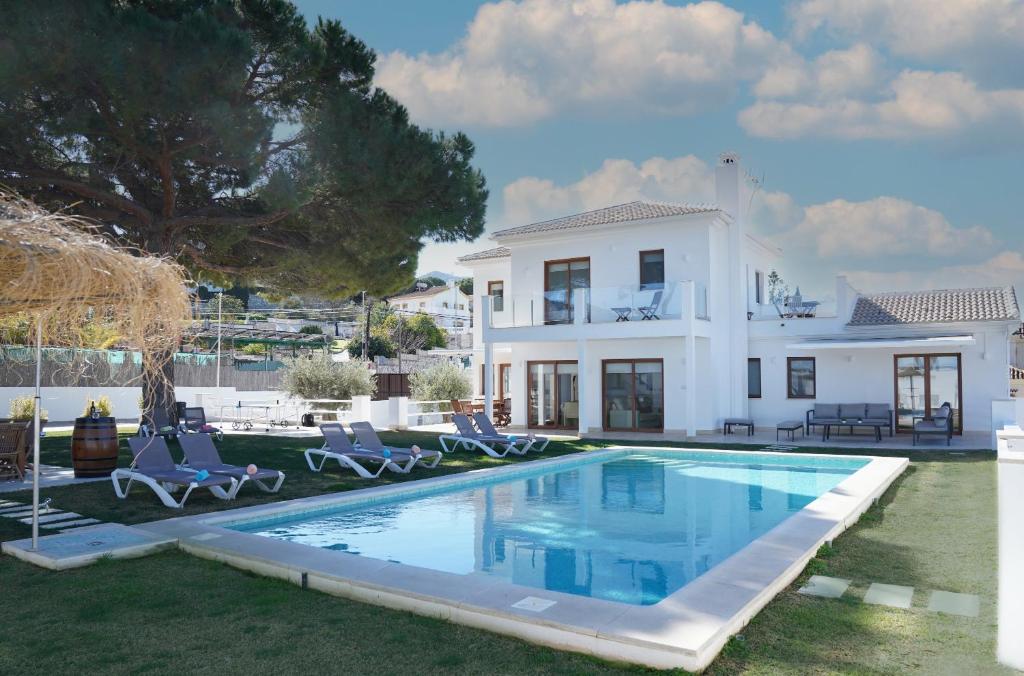 a villa with a swimming pool in front of a house at TESS Villa Maria in Alhaurín de la Torre