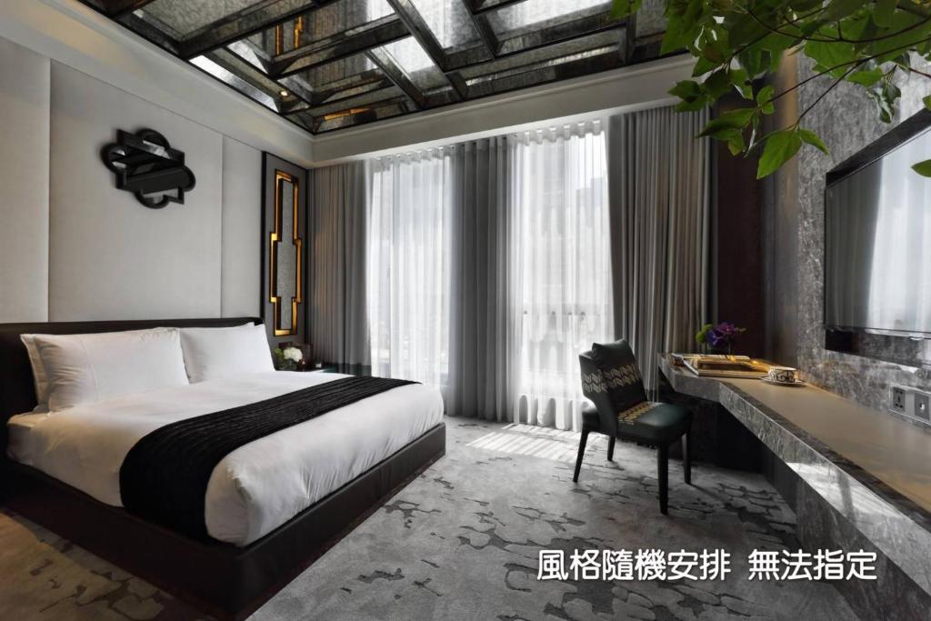 a hotel room with a bed and a desk and a bed at Boda Hotel in Taichung