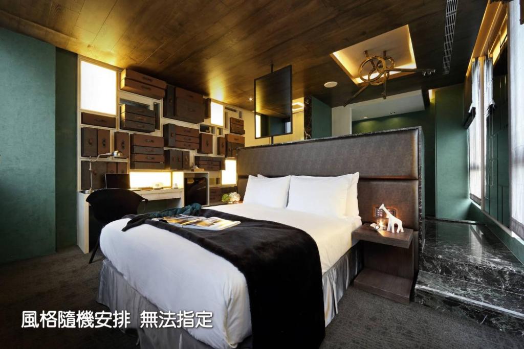 a bedroom with a large bed and a desk in it at Boda Hotel in Taichung