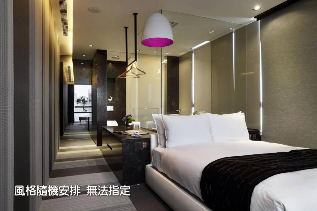 a bedroom with a large bed and a purple lamp at Boda Hotel in Taichung