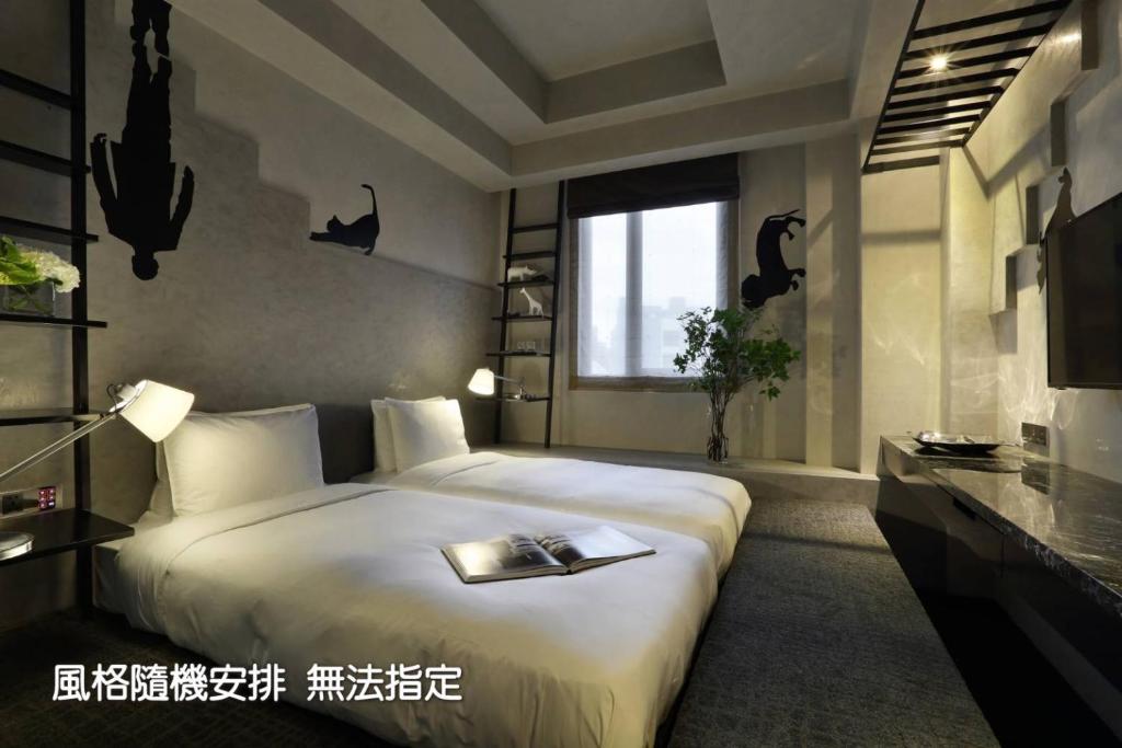 a bedroom with a bed with a book on it at Boda Hotel in Taichung