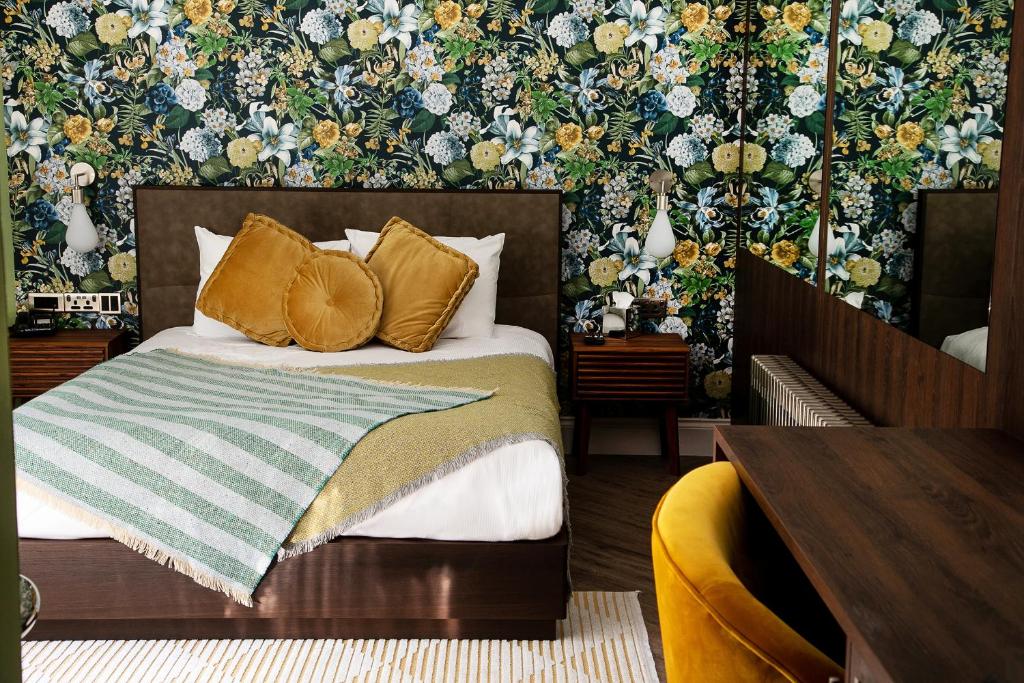 a bedroom with a bed with a floral wallpaper at Draycote Hotel And Whitefields Golf Course in Rugby