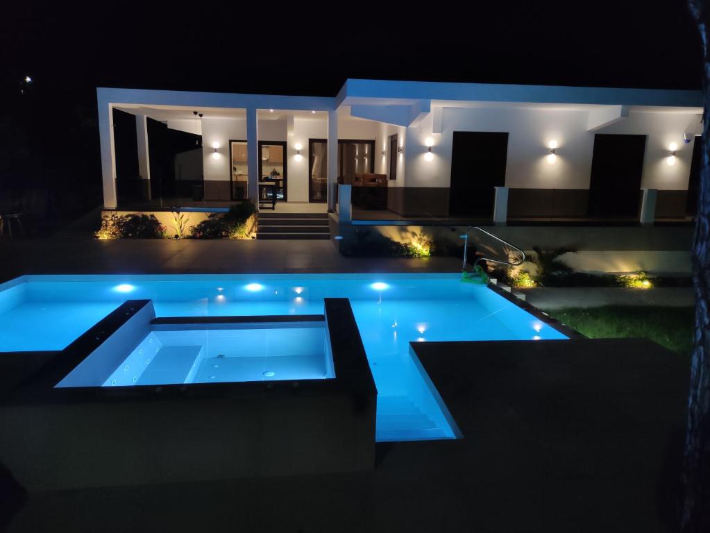 a swimming pool in front of a house at night at Luxury Villa Anemone with private pool in Pastida