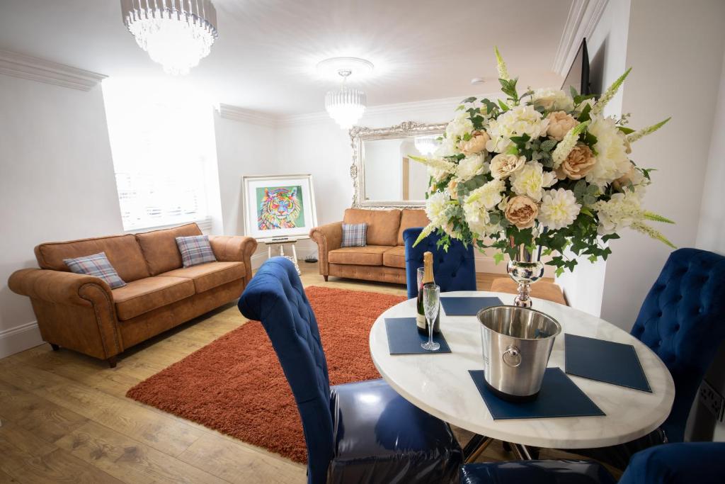 uma sala de estar com uma mesa com um vaso de flores em Ridley House Apartments em Yarm