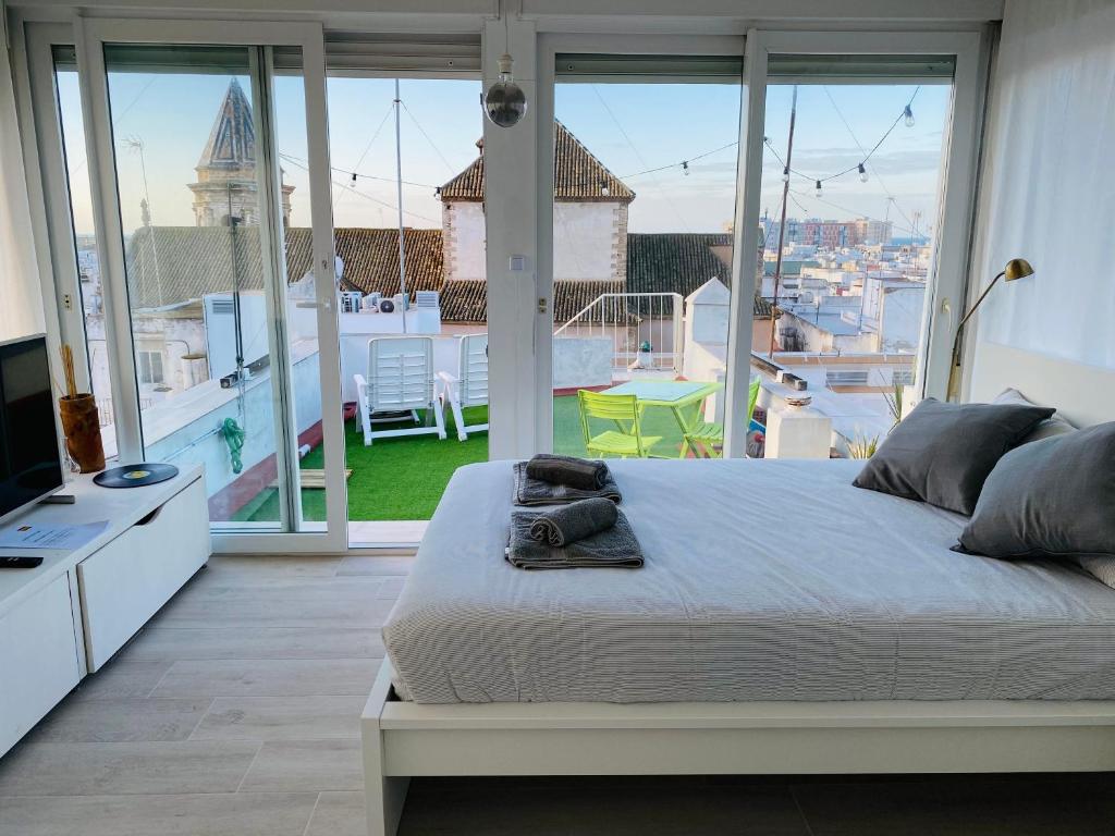 1 dormitorio con cama grande y ventana grande en Ático Cádiz 360 en Cádiz