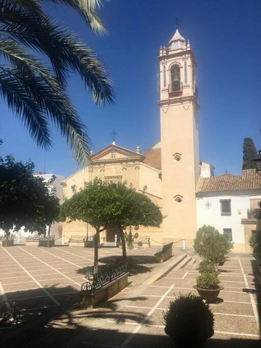 a large building with a clock tower in a courtyard at El rincón de Manolita #3 in Bornos