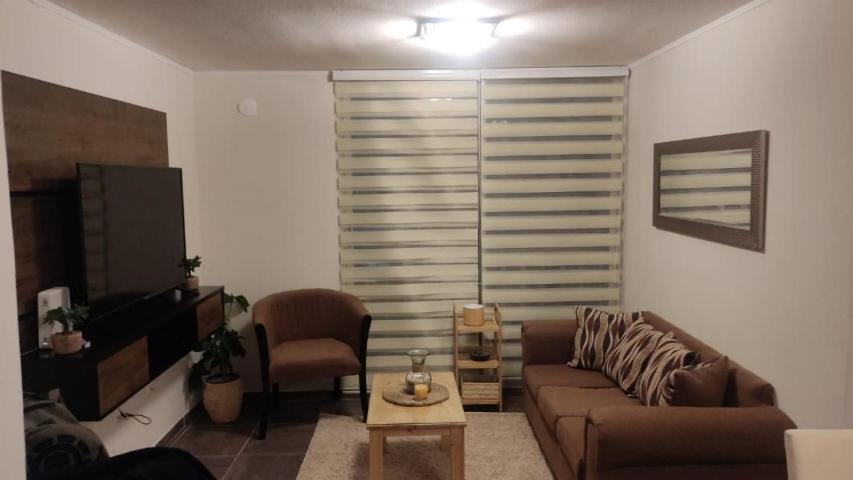 sala de estar con sofá y silla en Departamento full equipado, en La Serena