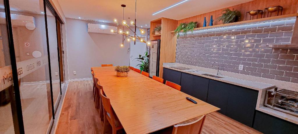 comedor con mesa de madera y barra en Blend Smart Style Estúdios Luxuosos e Decorados, en Goiânia