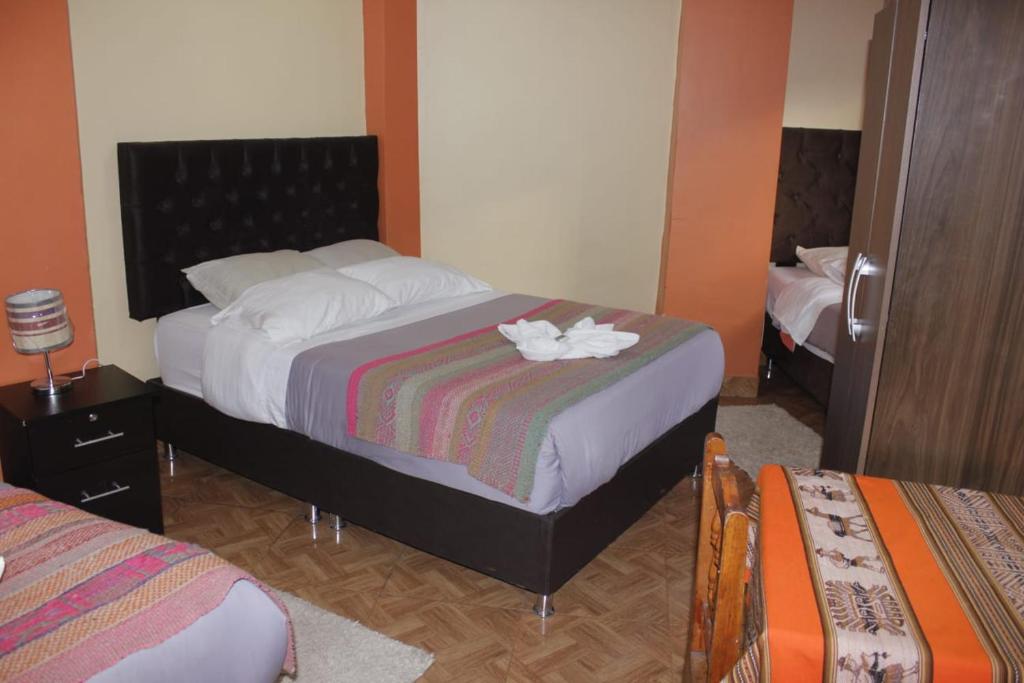 Un dormitorio con una cama con una flor. en hostal Qorisonqo inn ollantaytambo, en Ollantaytambo